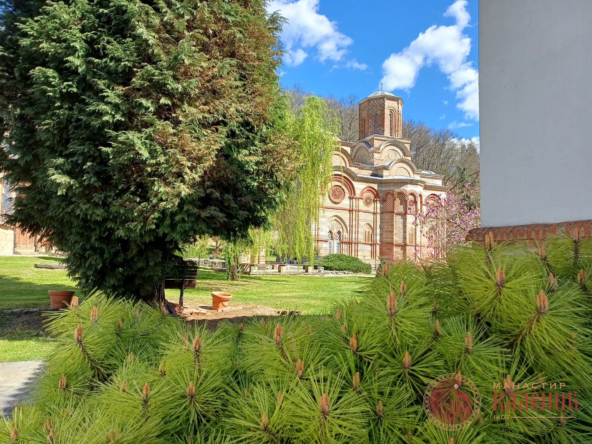 Црква манастира Каленић иза дрвећа у порти